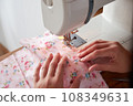 Hands of seamstress working on sewing machine. 108349631