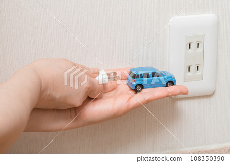 [Housewife charging an electric car] 108350390