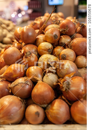 Fresh onions on the market close up photo. Onions big Golden on the counter market. Buying vegetables and food for cooking. Fresh onions on the market close up photo. Onions big Golden on the counter market. Buying vegetables and food for cooking. 108350678