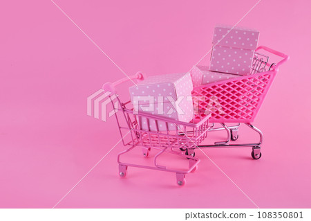 Pink friday concept. Online shopping.. Full shopping cart with presents. 108350801