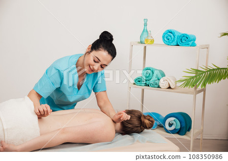 a woman massages a client in a massage room training spa healthy back a woman massages a client in a massage room training spa healthy back 108350986