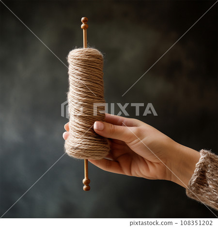 Woman's hand with spindle and yarn Woman's hand with spindle and yarn 108351202