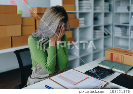 Starting small business entrepreneur of independent Asian woman showing her face worried about the sales of her business not reaching the target set. SME concepts. Starting small business entrepreneur of independent Asian woman showing her face worried about the sales of her business not reaching the target set. SME concepts. 108351376