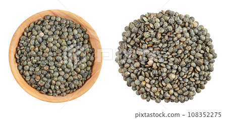 raw french green lentils in wooden bowl isolated on white background. Top view. Flat lay raw french green lentils in wooden bowl isolated on white background. Top view. Flat lay 108352275