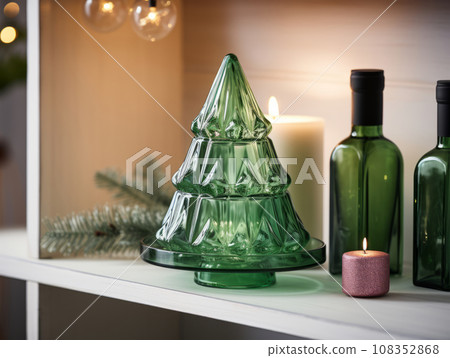 Decorative glass Christmas tree. Modern holiday decor. Trendy Christmas interior details on a shelf in the room. Decorative glass Christmas tree. Modern holiday decor. Trendy Christmas interior details on a shelf in the room. 108352868