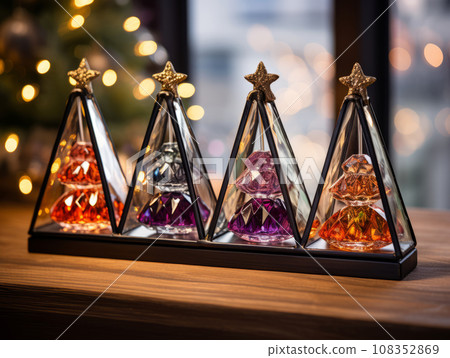 Christmas glass trees made of colored glass. Modern holiday decor. Trendy Christmas interior details on a shelf in the room. 108352869
