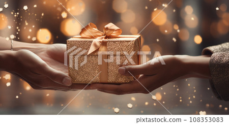 Hands of a woman with a New Year's gift box against a Christmas backdrop Hands of a woman with a New Year's gift box against a Christmas backdrop 108353083
