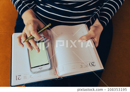 female entrepreneur at work. Work at home: A business woman uses a smartphone 108353195
