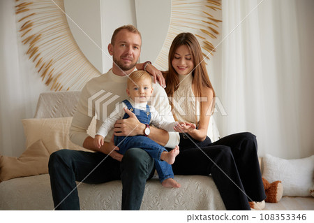Happy family moments together. Caucasian young happy family nurturing taking care of small little kid child toddler infant baby at home. Parenthood and adoption Happy family moments together. Caucasian young happy family nurturing taking care of small little kid child toddler infant baby at home. Parenthood and adoption 108353346