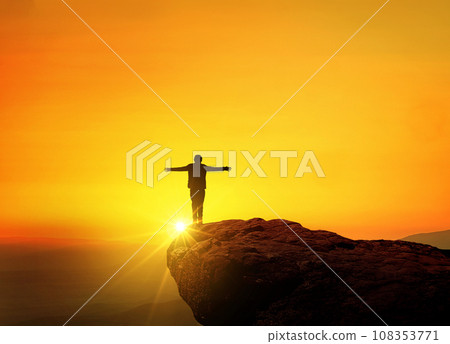 Successful man leader stands on top at sunset and enjoy, a creative idea. Freedom and rest, concept. Traveling and climbing a mountain Successful man leader stands on top at sunset and enjoy, a creative idea. Freedom and rest, concept. Traveling and climbing a mountain 108353771