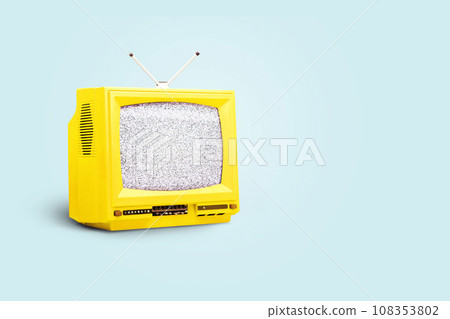 Yellow vintage TV with a white noise on a blue background. Creative idea, propaganda and media 108353802