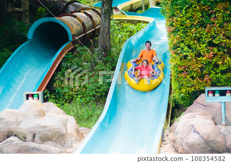 Kids on water slide. Family in aqua theme park. 108354582