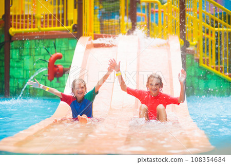 Kids on water slide. Family in aqua theme park. 108354684