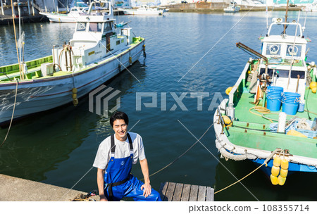 Young fishermen standing at the fishing port 108355714