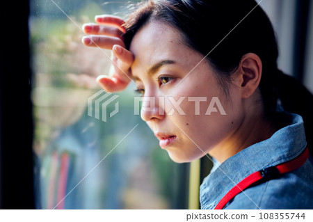 年輕女子把手放在窗邊的頭上 108355744