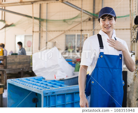 A young fisherman working at a fishing port A young fisherman working at a fishing port 108355948