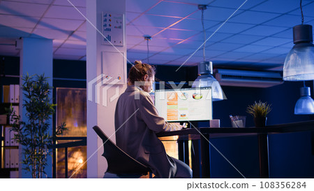 Corporate employee analyzing diagrams on screen, working on business analytics to increase profit at night. Executive manager planning startup development and growth with analytics. 108356284