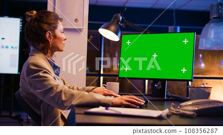Business manager using pc with green screen at desk, working on financial investment with chroma key display. Office worker looking at isolated mockup copyspace on computer. Handheld shot. Business manager using pc with green screen at desk, working on financial investment with chroma key display. Office worker looking at isolated mockup copyspace on computer. Handheld shot. 108356287
