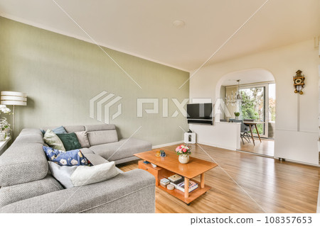 a living room with wood flooring and green wallpaper in the room is very spacious, but it's not too a living room with wood flooring and green wallpaper in the room is very spacious, but it's not too 108357653
