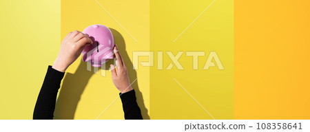 Person depositing money in a piggy bank 108358641