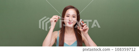 beautiful female using anti-aging treatment product on green,panorama beautiful female using anti-aging treatment product on green,panorama 108359712