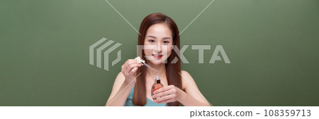 young beautiful female applying facial serum young beautiful female applying facial serum 108359713