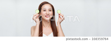 Young beautiful woman with cucumber slices on white background, panorama Young beautiful woman with cucumber slices on white background, panorama 108359764
