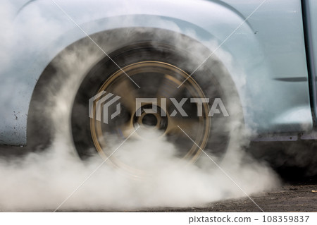 Drag car burning tire, Warm up tire before competition, Drag car wheel, Spinning wheel and smoke, Drag racing car burns rubber tires preparation for race. Drag car burning tire, Warm up tire before competition, Drag car wheel, Spinning wheel and smoke, Drag racing car burns rubber tires preparation for race. 108359837