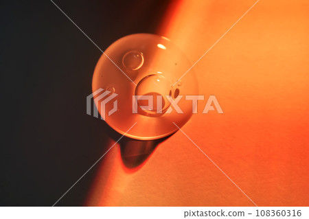 A drop of sunscreen body gel in the orange sunset light. A drop of sunscreen body gel in the orange sunset light. 108360316