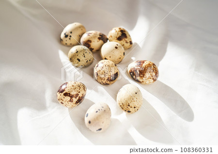 Quail eggs on a white linen towel close-up. Quail eggs on a white linen towel close-up. 108360331