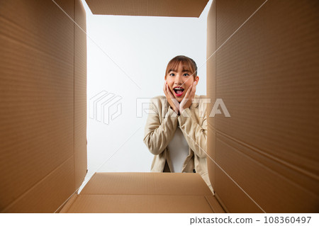 Surprised young asian woman unpacking Surprised young asian woman unpacking 108360497