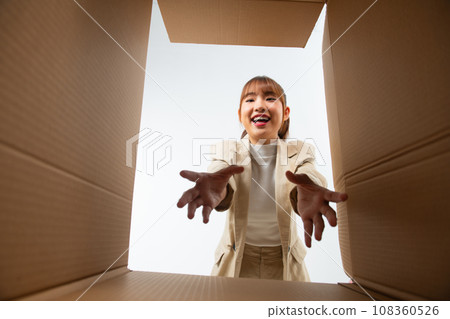 The surprised woman opening box and looking inside. The surprised woman opening box and looking inside. 108360526