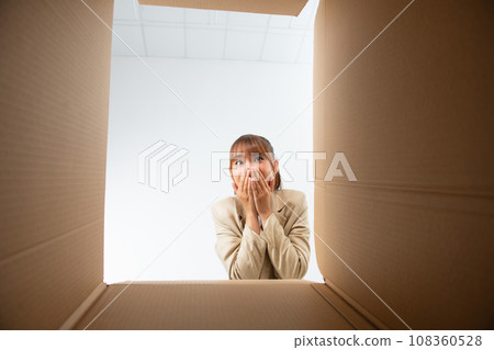 Happy Asian young woman opening carton box from internet store order shopping online at home Happy Asian young woman opening carton box from internet store order shopping online at home 108360528