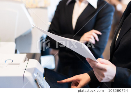 Young woman checking a printed document, no face 108360734