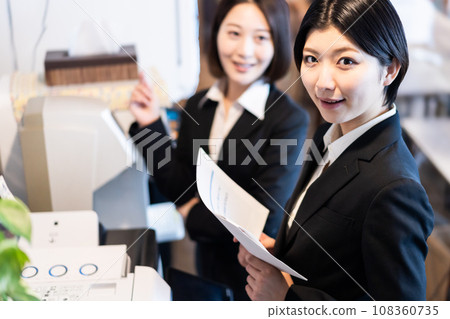 檢查印刷文件的年輕女子 檢查印刷文件的年輕女子 108360735