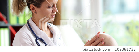 Lady dermatologist examines head skin of bald man in clinic 108361733