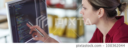 Smart woman checks code of program pointing pen to screen Smart woman checks code of program pointing pen to screen 108362044