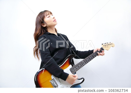Image of a woman playing an electric guitar 108362734