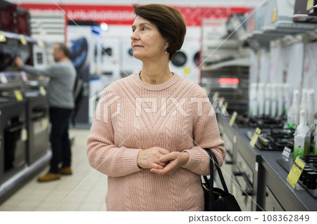 Mature woman choosing gas stove in appliance store Mature woman choosing gas stove in appliance store 108362849