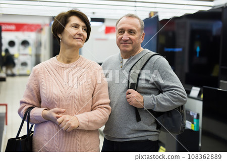Spouses of mature age walk through the departments of the store Spouses of mature age walk through the departments of the store 108362889