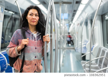 Portrait of woman with backpack standing in subway train 108362951