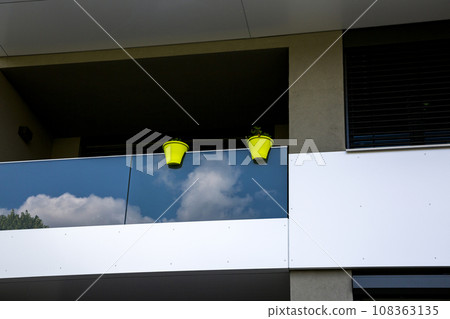 Two pots of flowers on the balcony of a residential building 108363135
