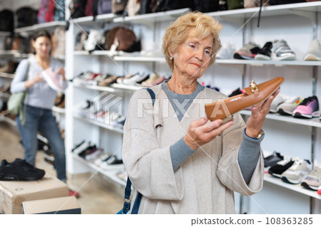 Portrait of a mature european woman choosing loafers 108363285