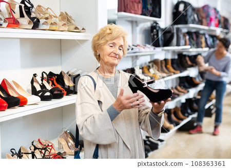 Mature woman chooses high heeled shoes Mature woman chooses high heeled shoes 108363361