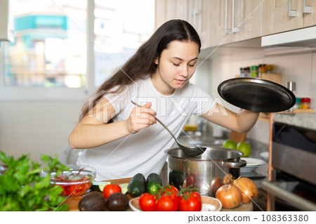 Woman holding cooking pot on kitchen Woman holding cooking pot on kitchen 108363380