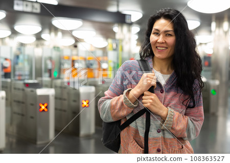 Asian woman passing through ticket gates in public transportation station 108363527