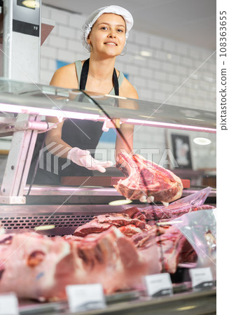 Girl seller works in specialized butcher shop Girl seller works in specialized butcher shop 108363655