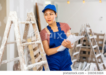 Woman worker checking documents during repair works 108363884