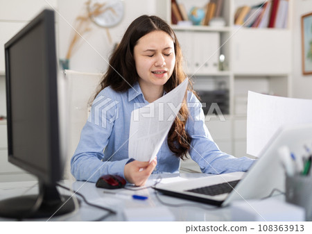 Tired businesswoman working with documents in office at table 108363913