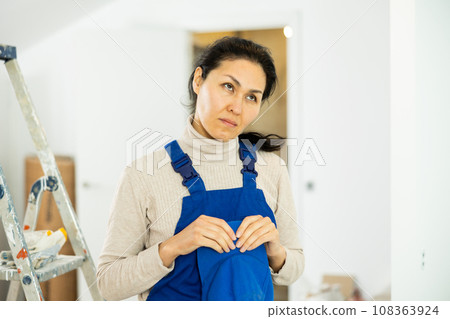 Sad woman builder standing in construction site Sad woman builder standing in construction site 108363924